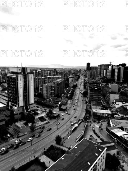 Black and white city view with modern buildings and sustained road traffic, Pristina, Kosovo