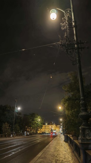 An illuminated street with street lamps and historic buildings at night, Prague, Czech Republic