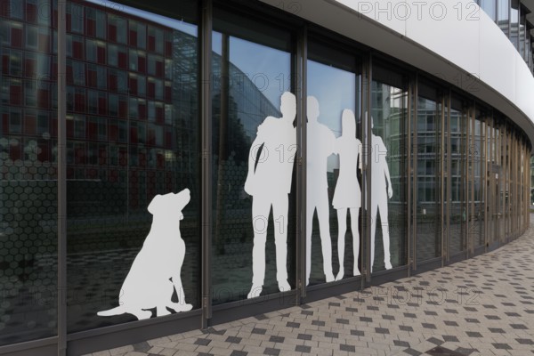Paper cut family with dog, sticker on window front of an office building, Medienhafen Düsseldorf, North Rhine-Westphalia, Germany