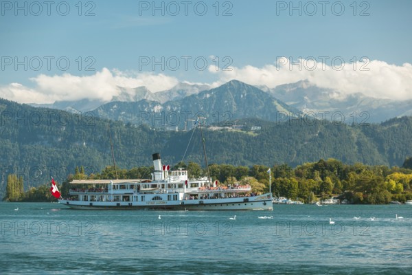 Lake Lucerne, Switzerland, Europe. A traditional boat on Lake Lucerne with the Swiss Alps in the background
