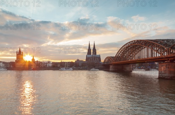 Cologne, Germany, Europe. The Cathedral and Iron Bridge from across the river at dawn