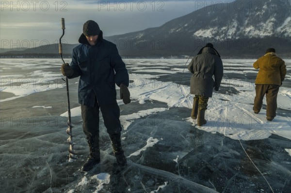 Lake Baikal, Siberia, Russia Far East. Traditional fishing on Lake Baikal frozen in Winter