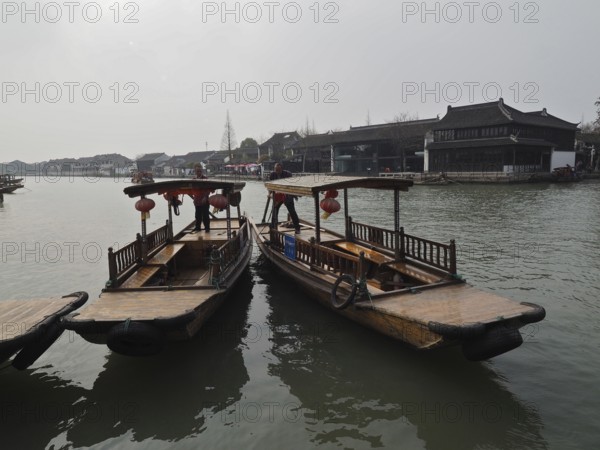 Two traditional boats with lanterns anchor on a quiet river in a Chinese city, Zhujiajiao Ancient Town, Shanghai, China