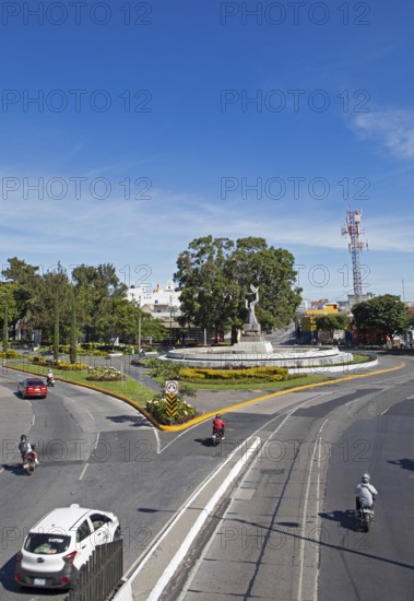 Street scene in zone 14 with the Peace Memorial or Monumento de la Paz in the back, Guatemala City, Guatemala Department, Guatemala