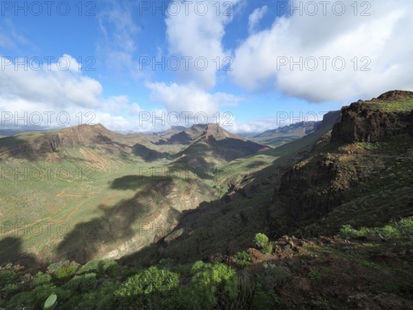Wide mountain landscape with green valleys and dramatic cloudy sky, Barranco de Fataga, Gran Canaria, Canary Islands, Canary Islands, Spain