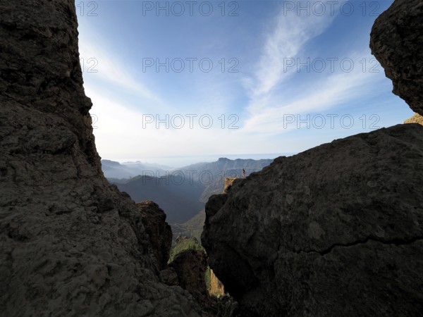 View through rocks of a vast mountain landscape under clear sky, Roque Nublo, Gran Canaria, Canary Islands, Canary Islands, Spain