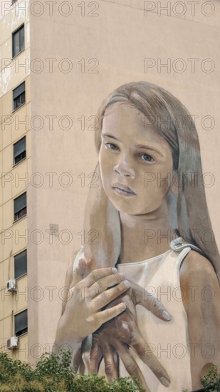 Large mural of a thoughtful girl on the façade of a building with natural facial expression, graffiti, Tirana, Albania
