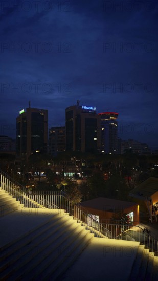 Nighttime city view with illuminated buildings and illuminated staircases in the foreground, Tirana, Albania