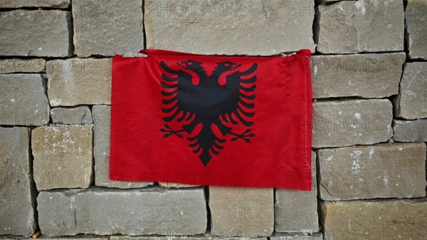 Albanian flag with black eagle on a red background on a stone wall, Tirana, Albania