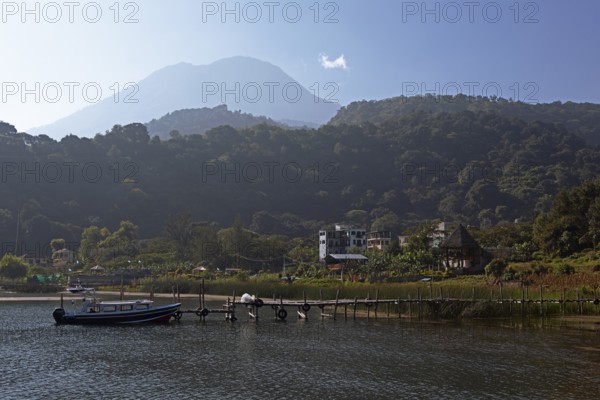 Colourful boats in the port of San Juan la Laguna, behind the Dan Pedro volcano in the haze, Atitlán, Sololá Department, Guatemala