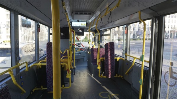 Interior of a public bus with empty seats, partly cordoned off with safety tapes and railings during corona, Berlin