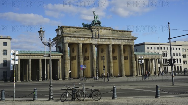 Famous gate in Berlin, Brandenburg Gate with a few bicycles in the foreground and blue sky, deserted during corona, Berlin