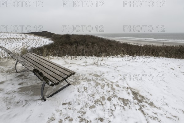 Bench in snowy dune landscape, Langeoog, Lower Saxony, Germany