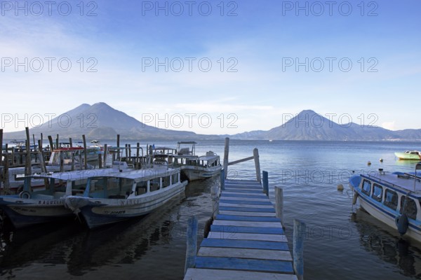 Boats on the pier, Lake Atitlán or Lake Atitlán in the morning, the volcanoes San Pedro, Atitlán and Toliman in the back, Panajachel, Sololá Department, Guatemala