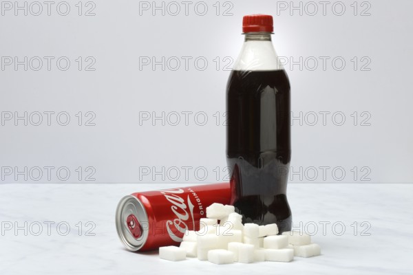 Cola drink in bottle and can, lots of sugar cubes