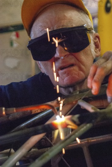 Old worker, welder, metal construction, working into old age, pensioner, car, safety glasses, connect