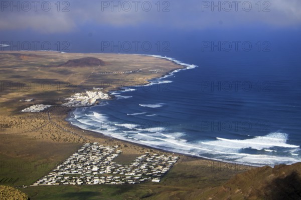Wide coastline with bright waves and the seaside village of Caleta de Famara by the sea, Mirador de Ermita de Las Nieves, Lanzarote