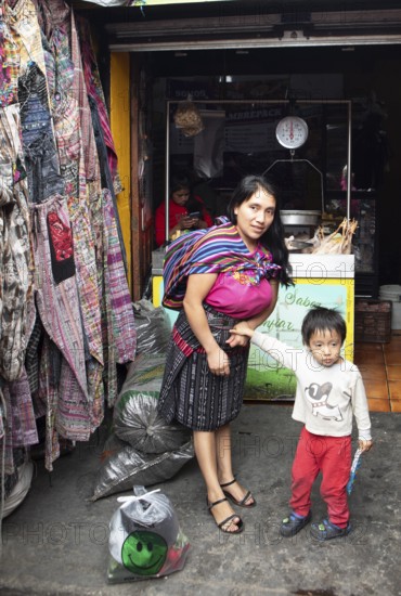 Mayan woman with toddler in traditional clothes at the market in Chichicastenango, Highlands, El Quiché Department, Guatemala