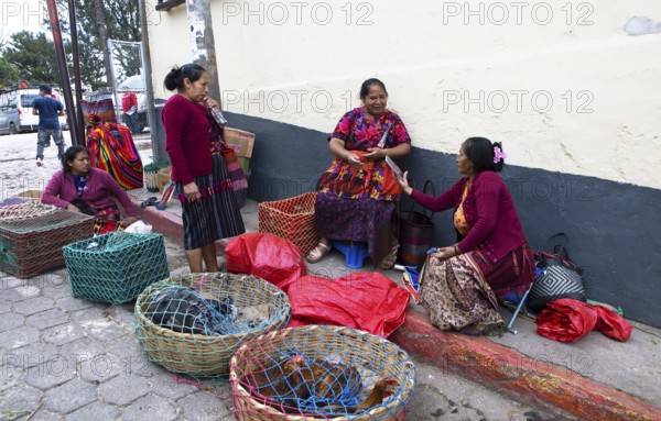 Mayan woman wearing traditional clothing sell chickens on the street in Chichicastenango, Highlands, El Quiché Department, Guatemala