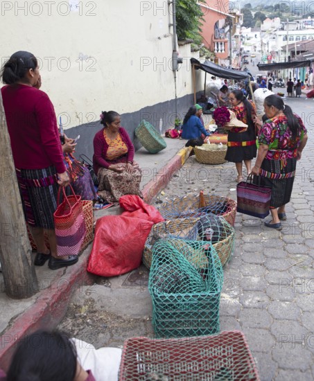 Mayan woman wearing traditional clothing sell chickens on the street in Chichicastenango, Highlands, El Quiché Department, Guatemala