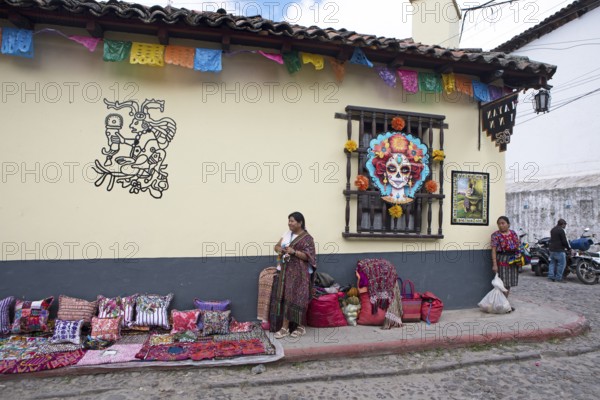Mayan woman wearing traditional clothing on a decorated house façade, Chichicastenango market, Highlands, El Quiché Department, Guatemala