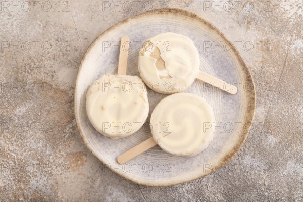 ?hocolate Ice cream in white glaze, on brown concrete background, top view, flat lay, close up, minimalism