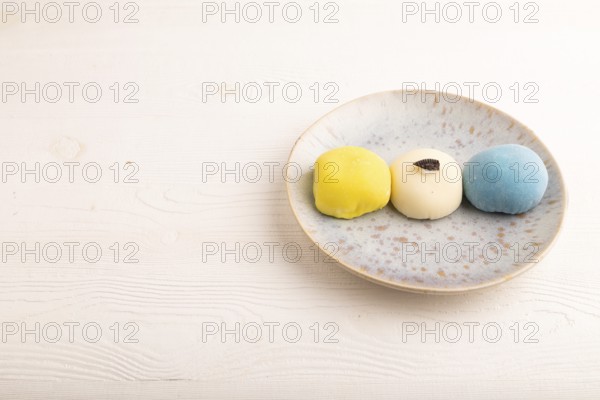Japanese Mochi Cakes on white wooden background, side view, copy space