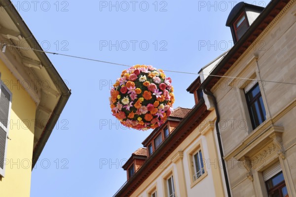 Ettlingen, Germany - August 13th 2025: Floral sphere of flowers hanging above street as summer decoration