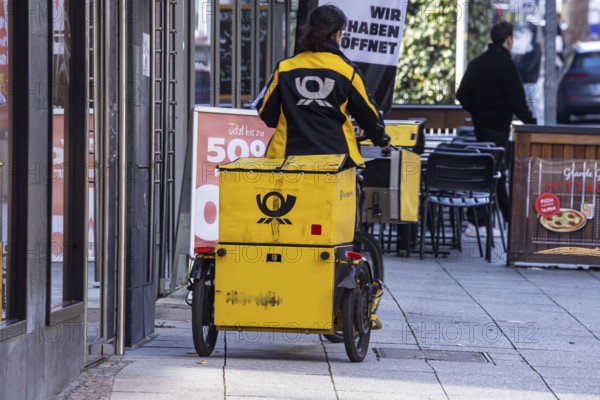 Deutsche Post mailman out and about with his bicycle. Stuttgart, Baden-Württemberg, Germany