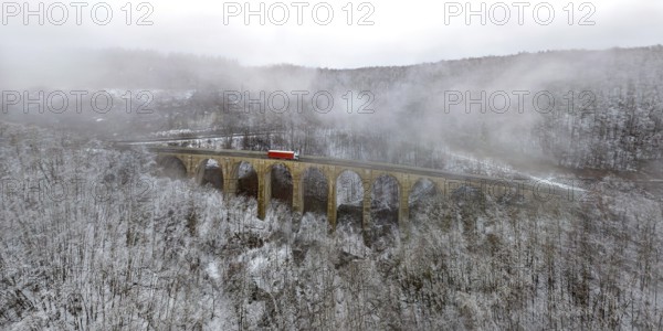 Dragon hole bridge on the A8 motorway, motorway bridge on the Drackenstein slope on the Swabian Jura in snow and fog. Drone photo. panoramic photo. Drackenstein, Baden-Württemberg, Germany