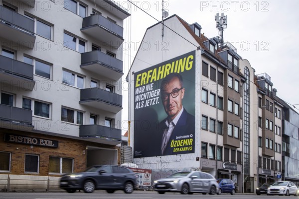 Mega poster on a house pediment. Cem Özdemir, leading candidate of the Green Party. 2026 state election in Baden-Württemberg. Election advertising in the city center of Stuttgart. Stuttgart, Baden-Württemberg, Germany