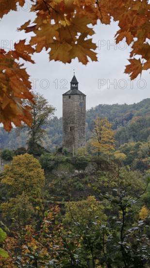 A historic tower perches on a wooded hill amidst autumn colors, Fichtelgebirge, Germany