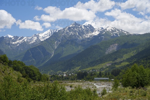 Majestic snow-capped mountains under a cloudy sky, view from Majvdieri of Mount Tetnuldi, Mestia Municipality, Mulkhra River, Road 7, Mingrelia and Upper Svaneti Region, High Caucasus, Georgia
