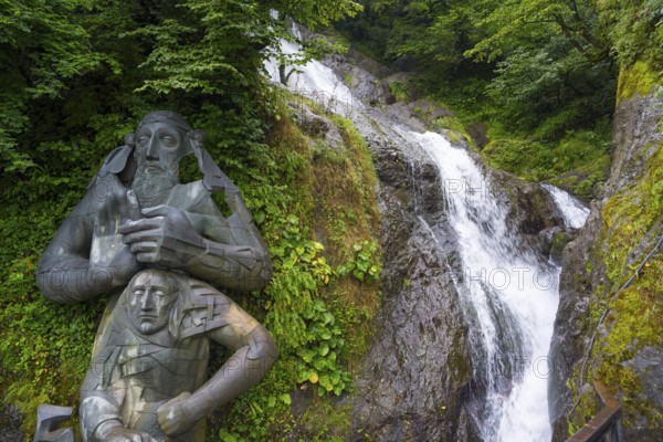 Sculpture in the forest next to a rushing waterfall, statue of Saint Andrew and waterfall of Saint Andrew, Apostle Andrew the First-Called, near the border crossing with Turkey, Sarpi, Autonomous Republic of Adjara, Georgia