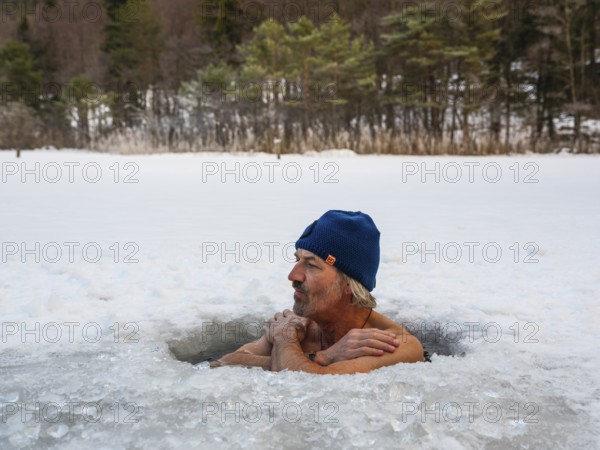 Man with cap, 55, ice bathing in an ice hole, Thumsee, Bad Reichenhall, Berchtesgadener Land, Upper Bavaria, Bavaria, Germany