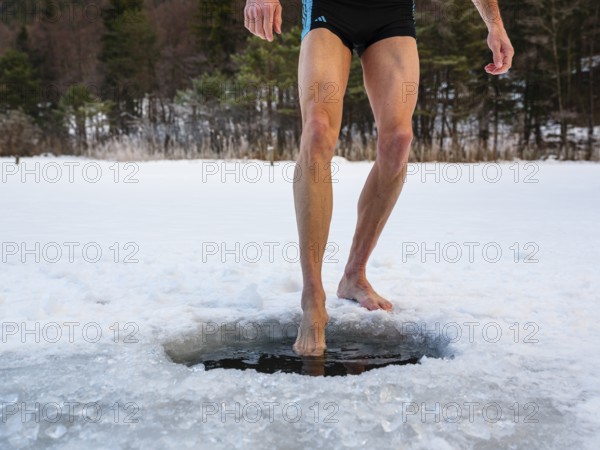 Naked men's legs at an ice hole, toes in water, Thumsee, Bad Reichenhall, Berchtesgadener Land, Upper Bavaria, Bavaria, Germany