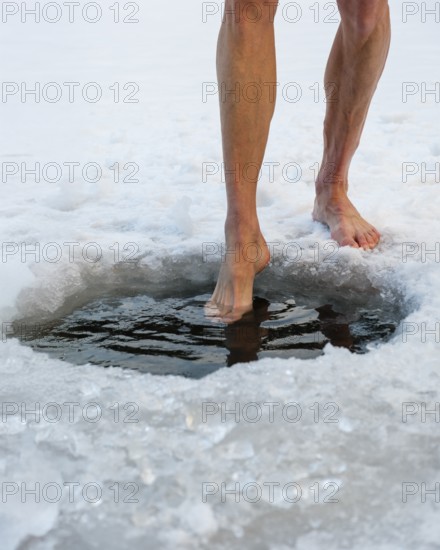 Naked men's legs at an ice hole, toes in water, Thumsee, Bad Reichenhall, Berchtesgadener Land, Upper Bavaria, Bavaria, Germany