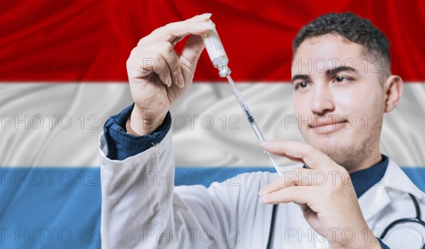 Doctor holding syringe on Luxembourg flag background. Medical professional holding syringe with Luxembourgish flag in the background