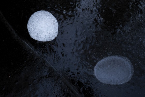 Air bubbles in the ice of a frozen lake in winter, Finland