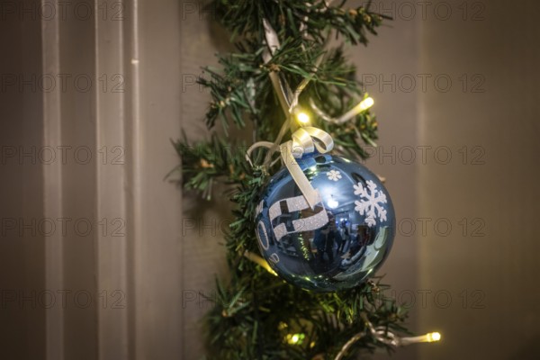 Blue Christmas ball with Finland flag and snowflakes, fairy lights, pine branch, Finland