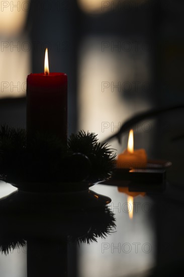 Two candles stand on a table in front of a window at dusk and create a Christmas atmosphere, Finland
