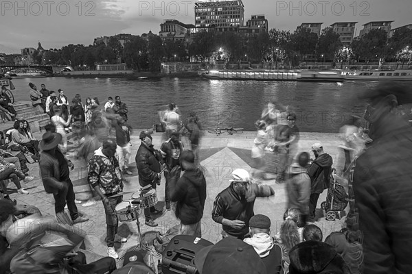 Music and dance by young people in the evenings on the Seine, black and white, Paris, France