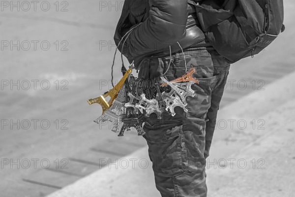 Street vendor with Eiffel Tower souvenirs on his arm, black and white, Paris, France