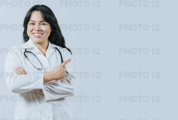 Smiling asian female doctor recommending an advertisement. Asian young doctor pointing to the side isolated