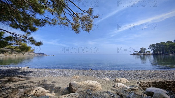 A peaceful pebble beach with a view of the calm sea and clear skies, Antalya, Turkey