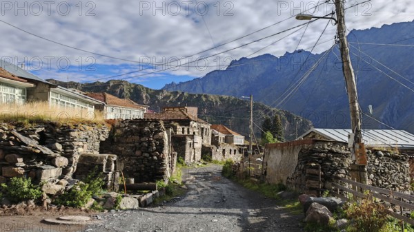 Rustic village in the mountains with old stone houses and power lines, Georgia