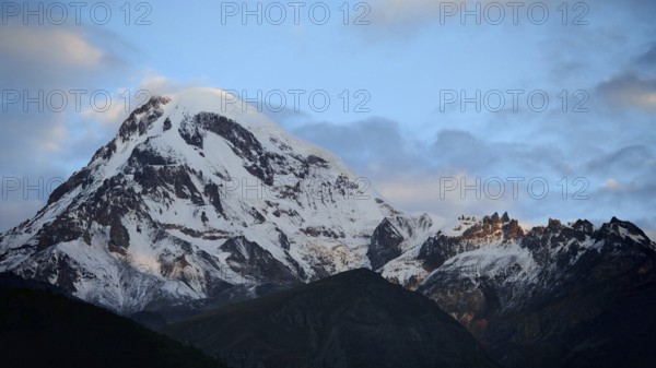 Majestic snow-covered mountain under cloudy sky, Kazbek, Stepantsminda, Georgia