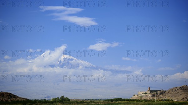 Extensive mountain landscape with a small monastery and cloudy sky, Khor Virap with Ararat in the background, Armenia