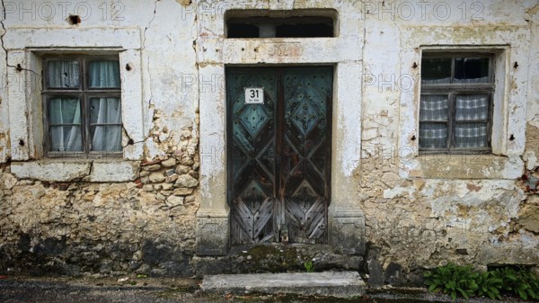 Weathered stone wall with old wooden door and two windows, Franconian Switzerland, Upper Franconia