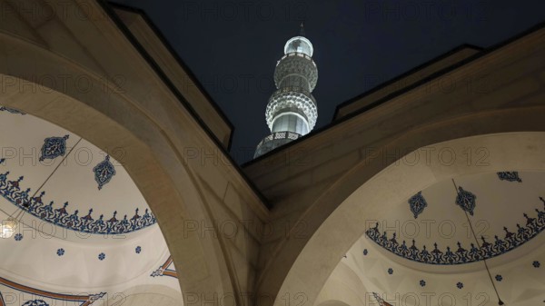 Night view of a mosque with minaret and ornamental arches, Tirana, Albania